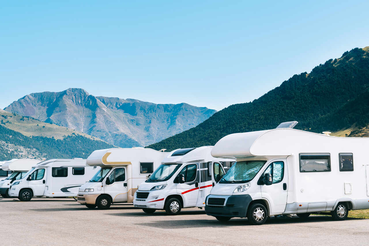 Motorhomes agrupadas com montanhas atrás